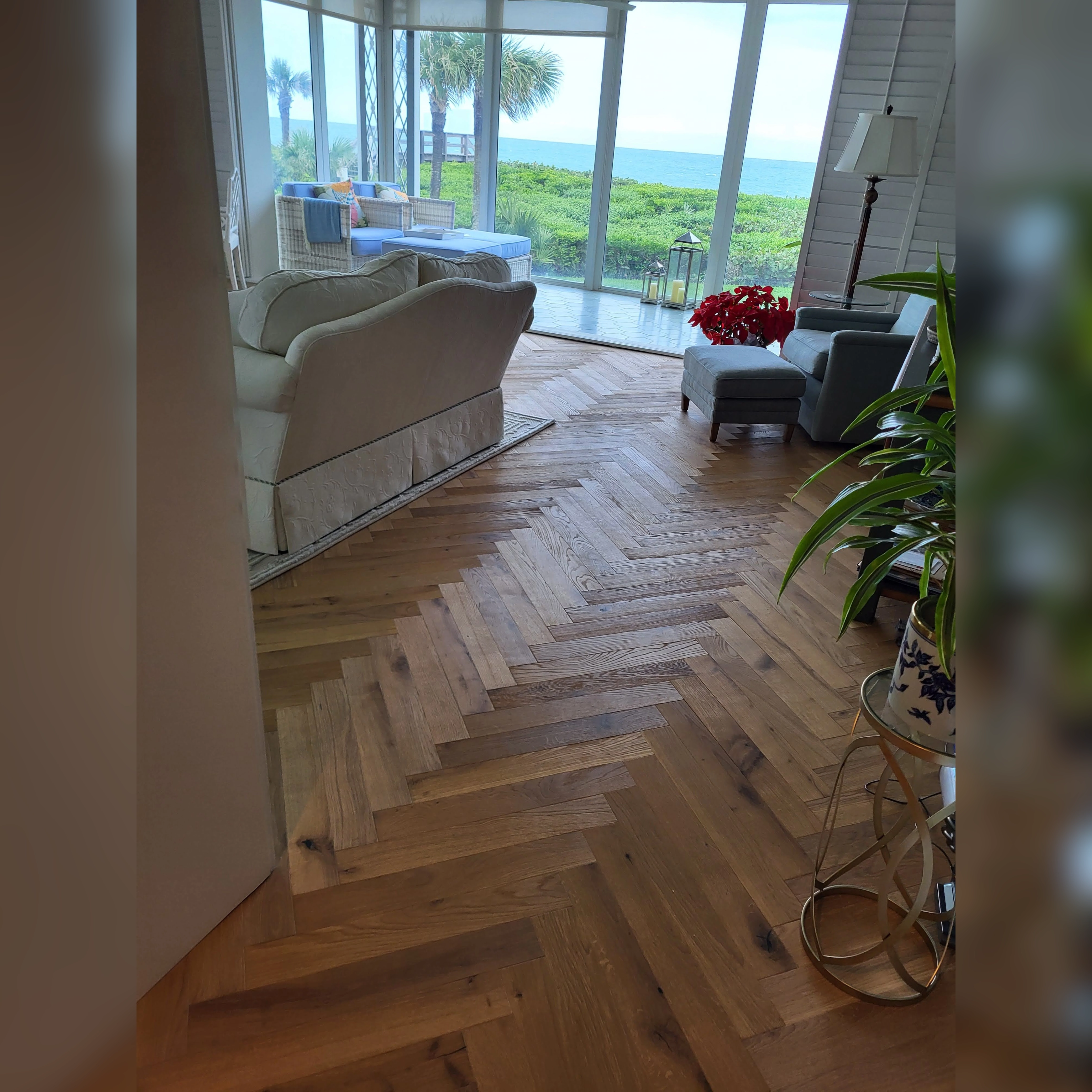 This kitchen features durable engineered wood flooring with a smooth, natural finish, complementing the warm wood tones of the central island and the bright, open design of the space.